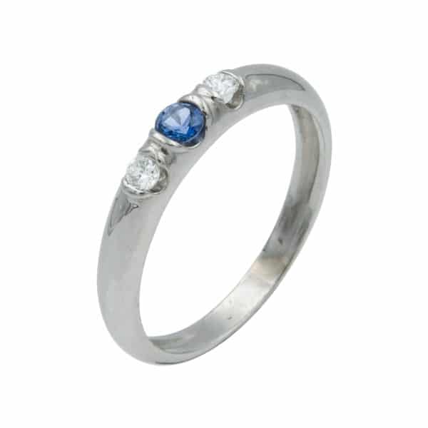 Lumina est une bague en or blanc 750/1000ème. Au centre un saphir taille brillant accompagnée sur les cotés de 2 diamants taille brillant. - oblique