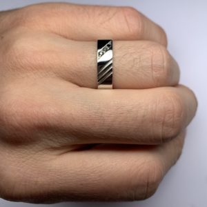 Racer est une bague en argent 925/1000ème de forme carré avec 3 stries. Elle est accompagnée de 3 Diamants noirs. - Sur main